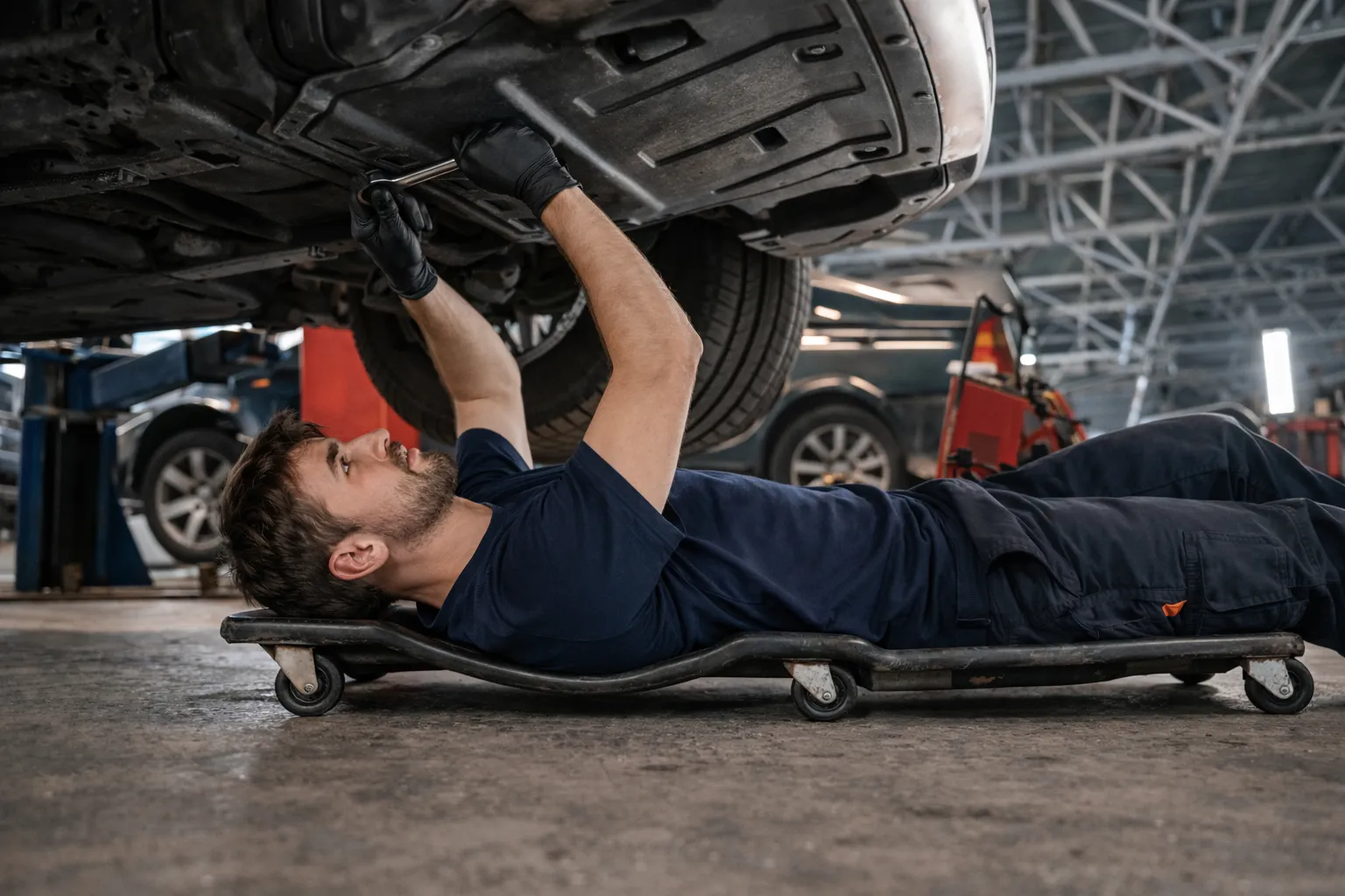 Svensk mekaniker i blå arbetskläder, porträtt framför sin verkstad